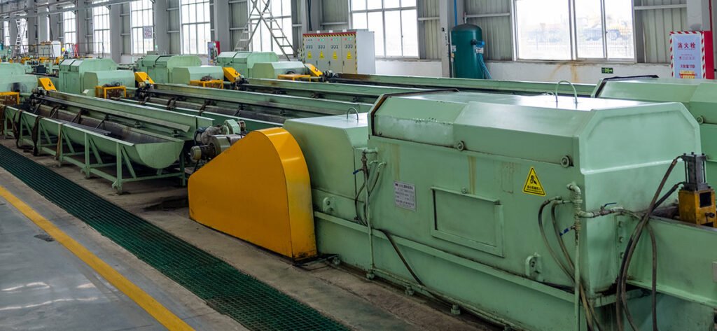 Factory view showing steel tube billets undergoing the hot piercing process in a heating furnace